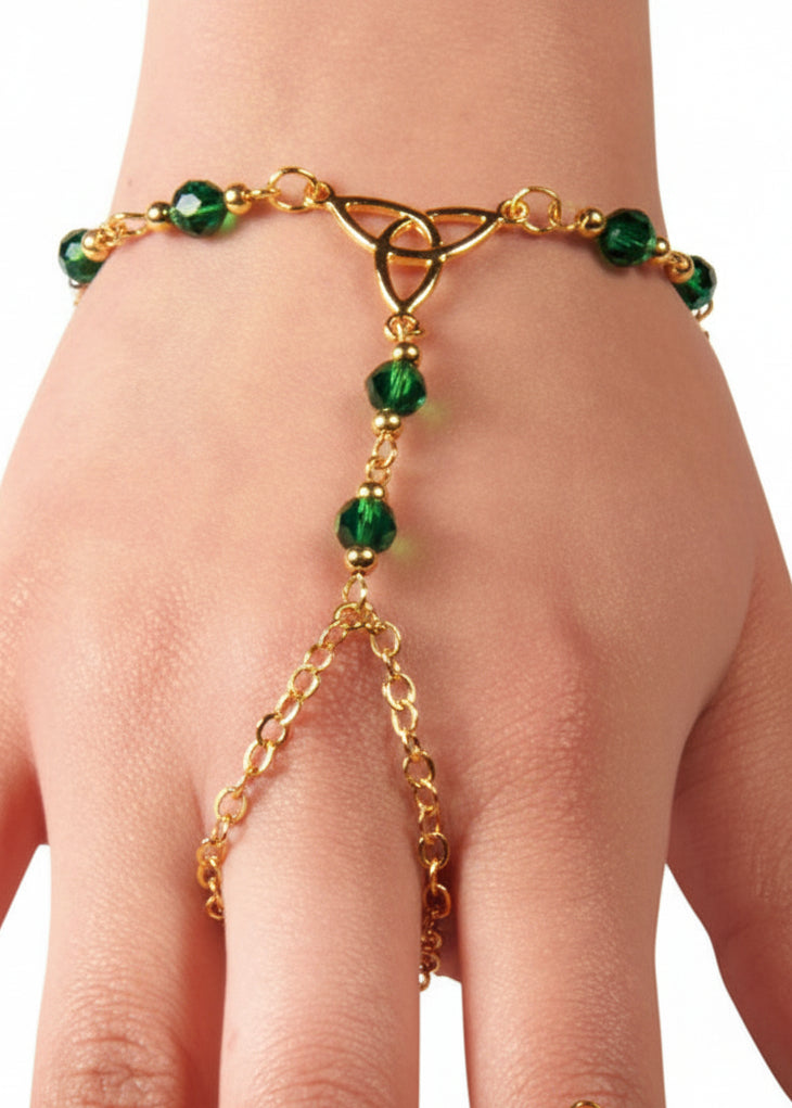 Gold Celtic eternity knot hand chain finger bracelet with green bead accents worn on hand
