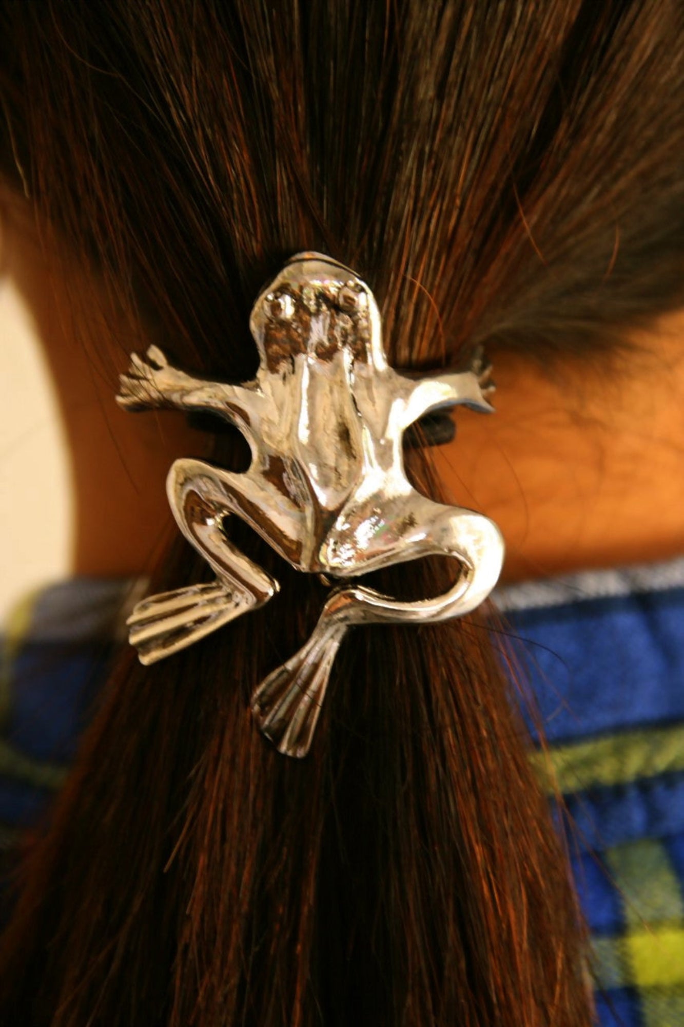 Silver frog ponytail hair hook securing ponytail, back view