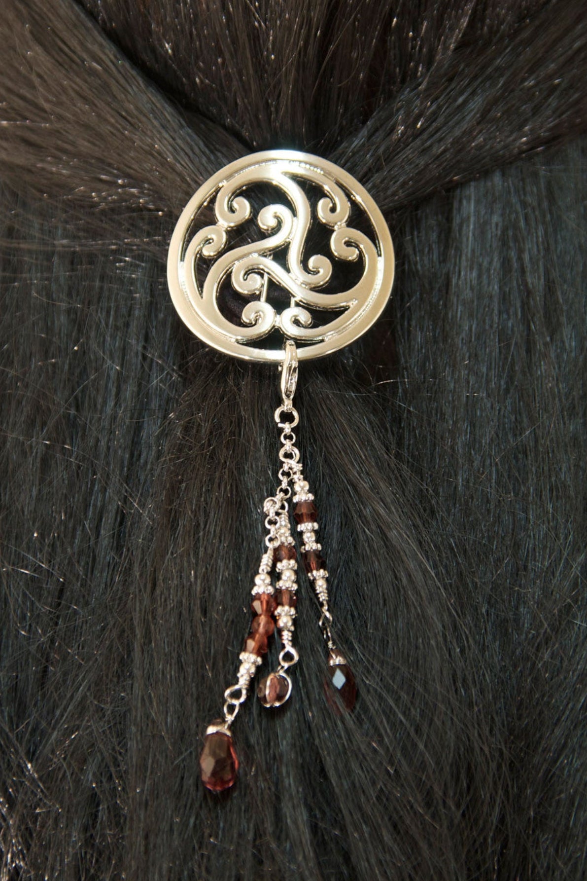Silver Celtic scrollwork hair hook with bead charms worn in dark hair