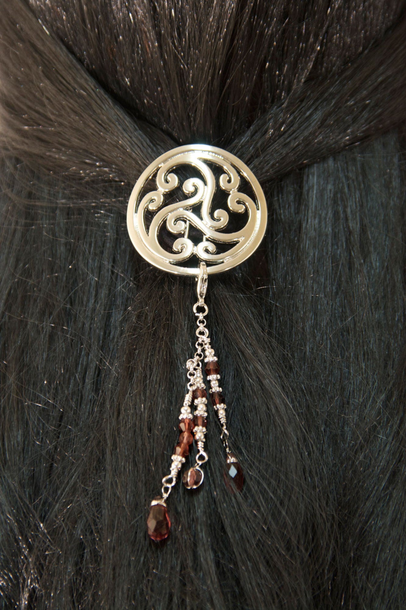 Silver Celtic scrollwork hair hook with bead charms worn in dark hair