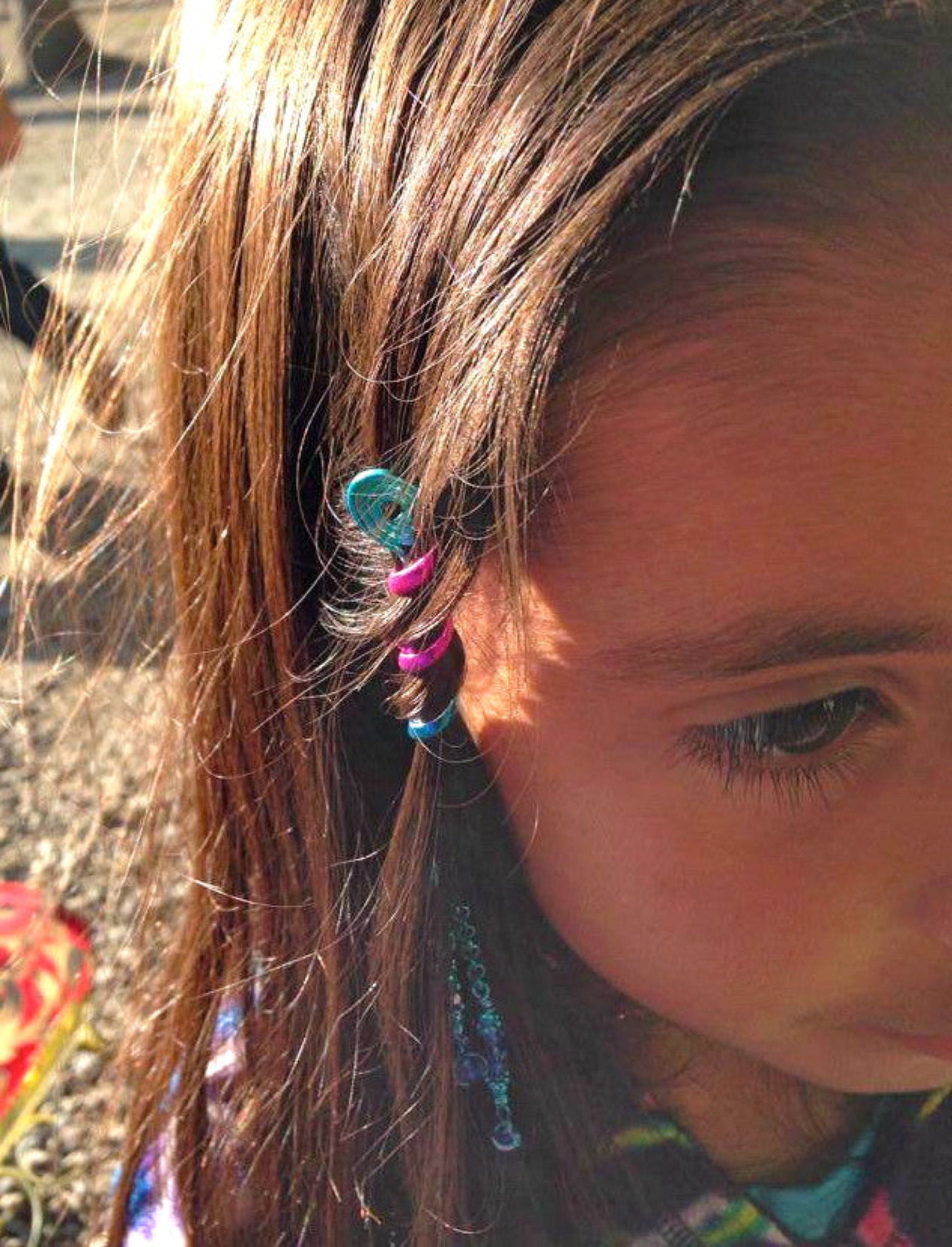 Blue rainbow 2 inch spiral hair twister worn in brown hair, side view