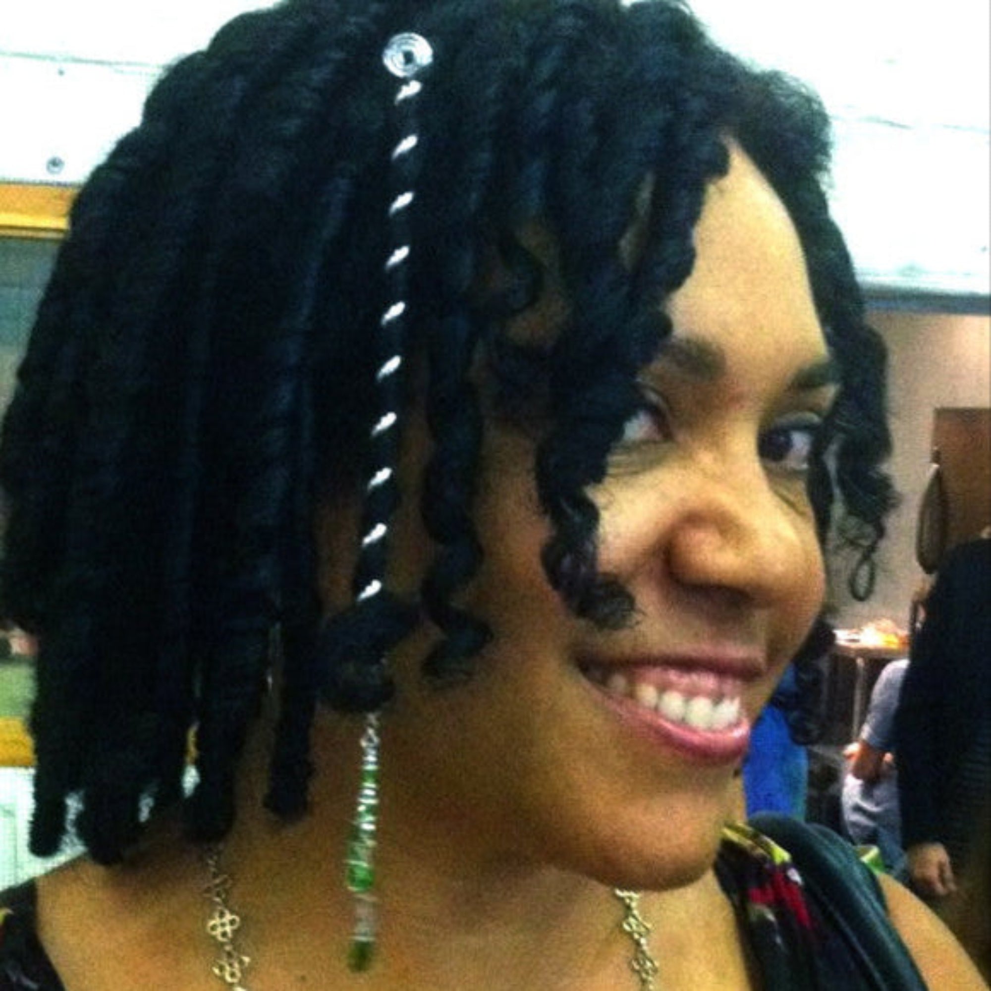 Model wearing silver 6 inch spiral hair wrap in curly textured hair, lifestyle view