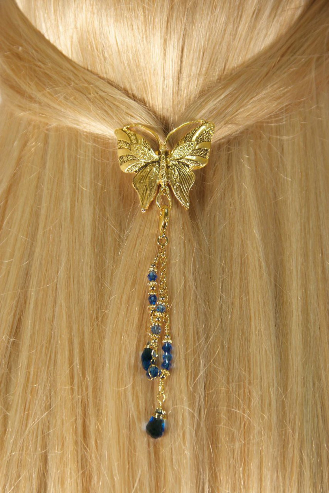 Gold butterfly hair hook ponytail holder with dangling blue crystal bead charms worn in blonde ponytail, back view