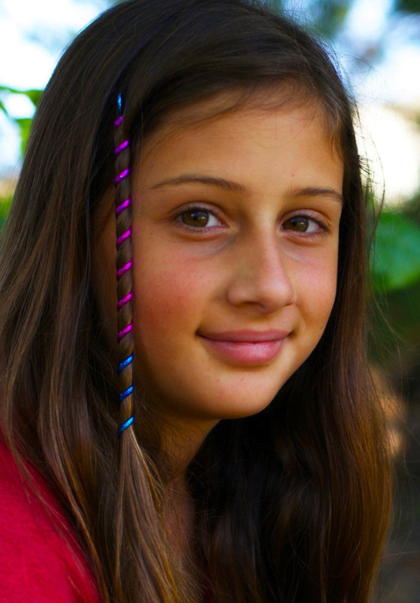 6 inch rainbow spiral hair twister in blue and magenta worn in long brown hair, front view