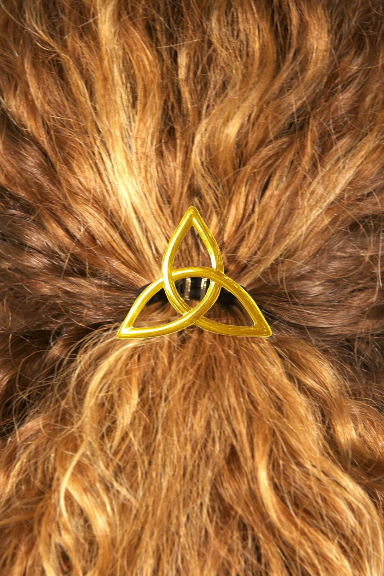 Gold Celtic eternity knot hair hook worn in curly red hair, back view