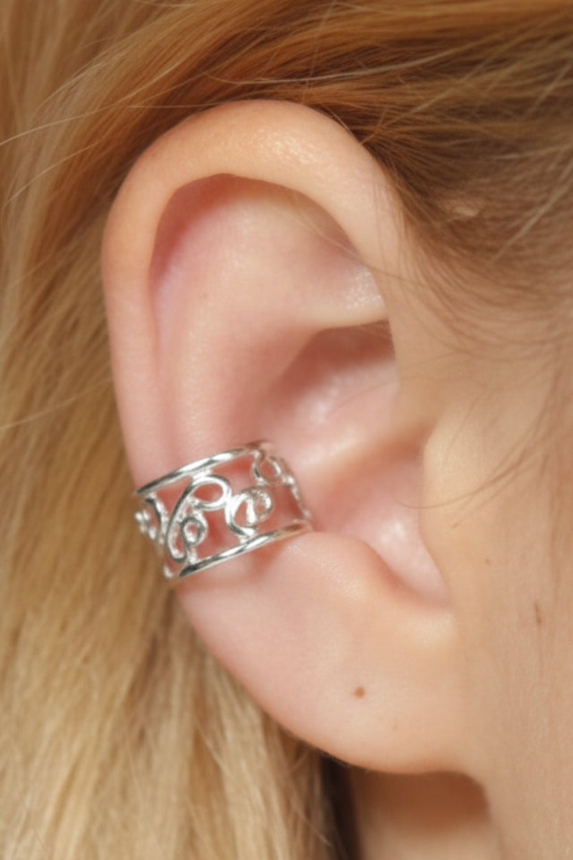 Model wearing adjustable silver spiral ear cuff, side view