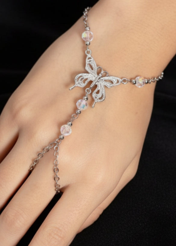 hand wearing silver hand chain bracelet with butterfly pendant and finger loop