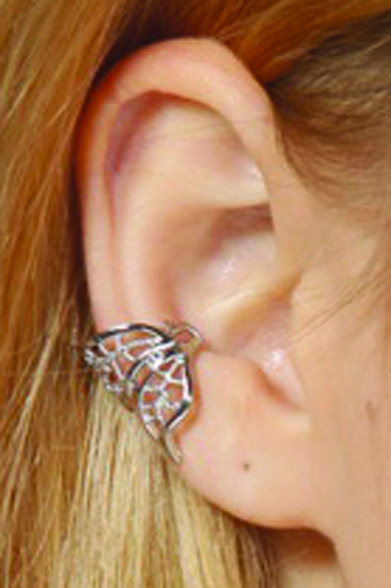 ear wearing silver filigree ear cuff with curved wing design