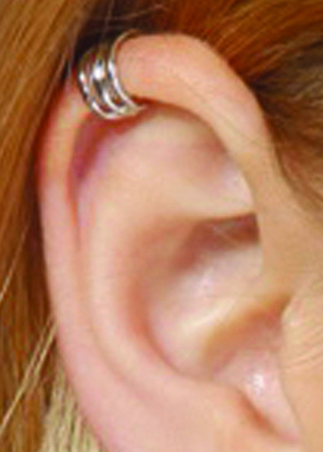 Model wearing silver triple-band ear cuff, non-piercing wrap style, helix placement
