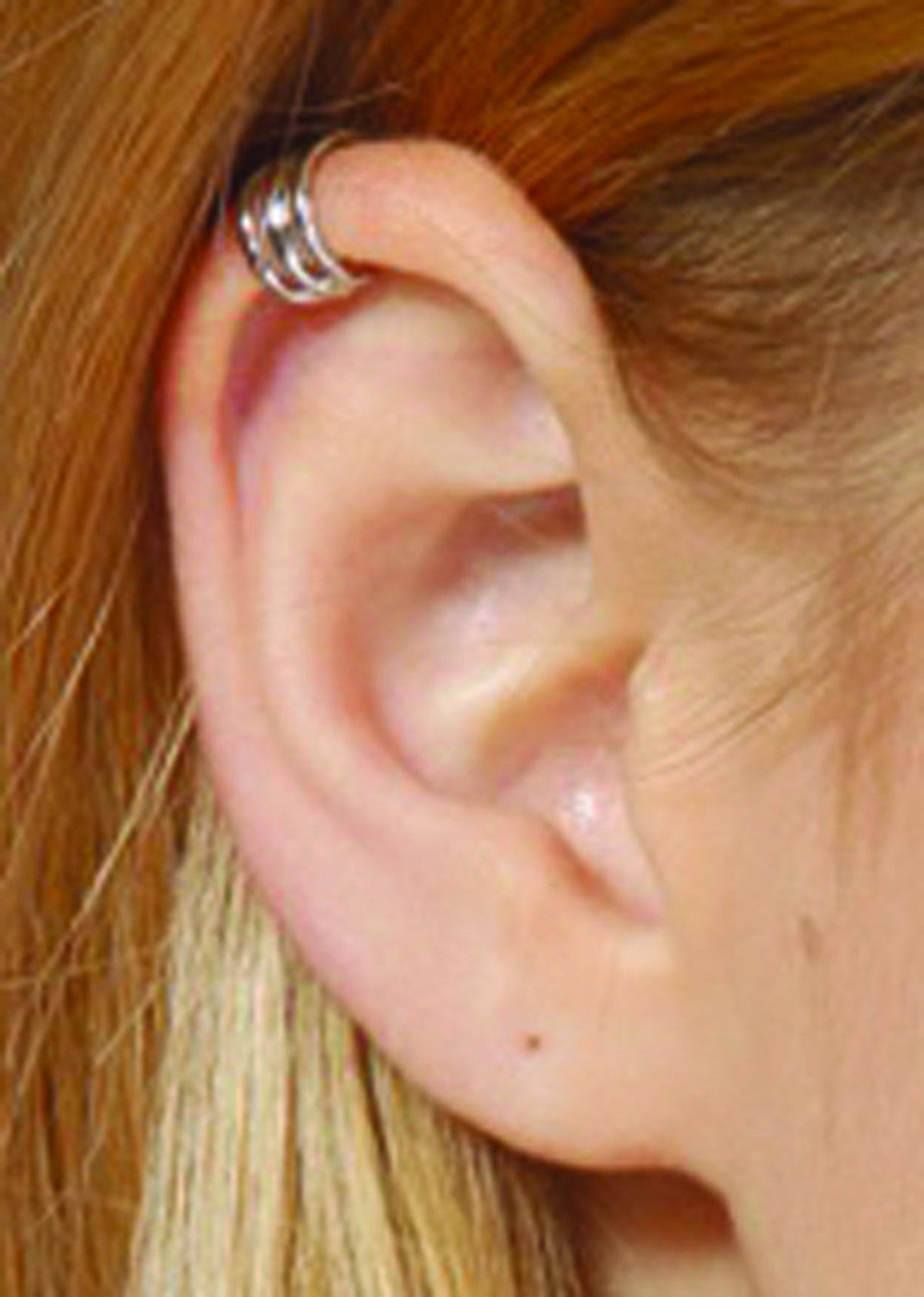 Model wearing silver triple-band ear cuff, non-piercing wrap style, helix placement