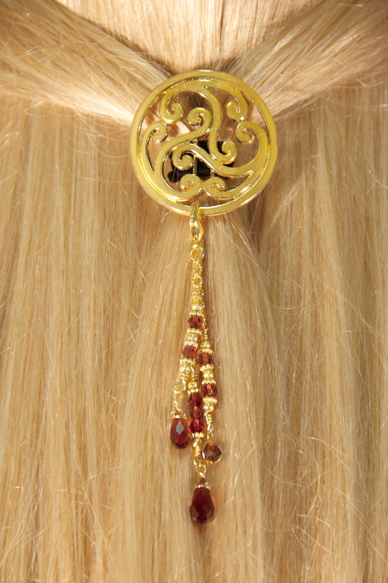 Gold Celtic circle hair hook with dangling red bead charms worn in ponytail, back view